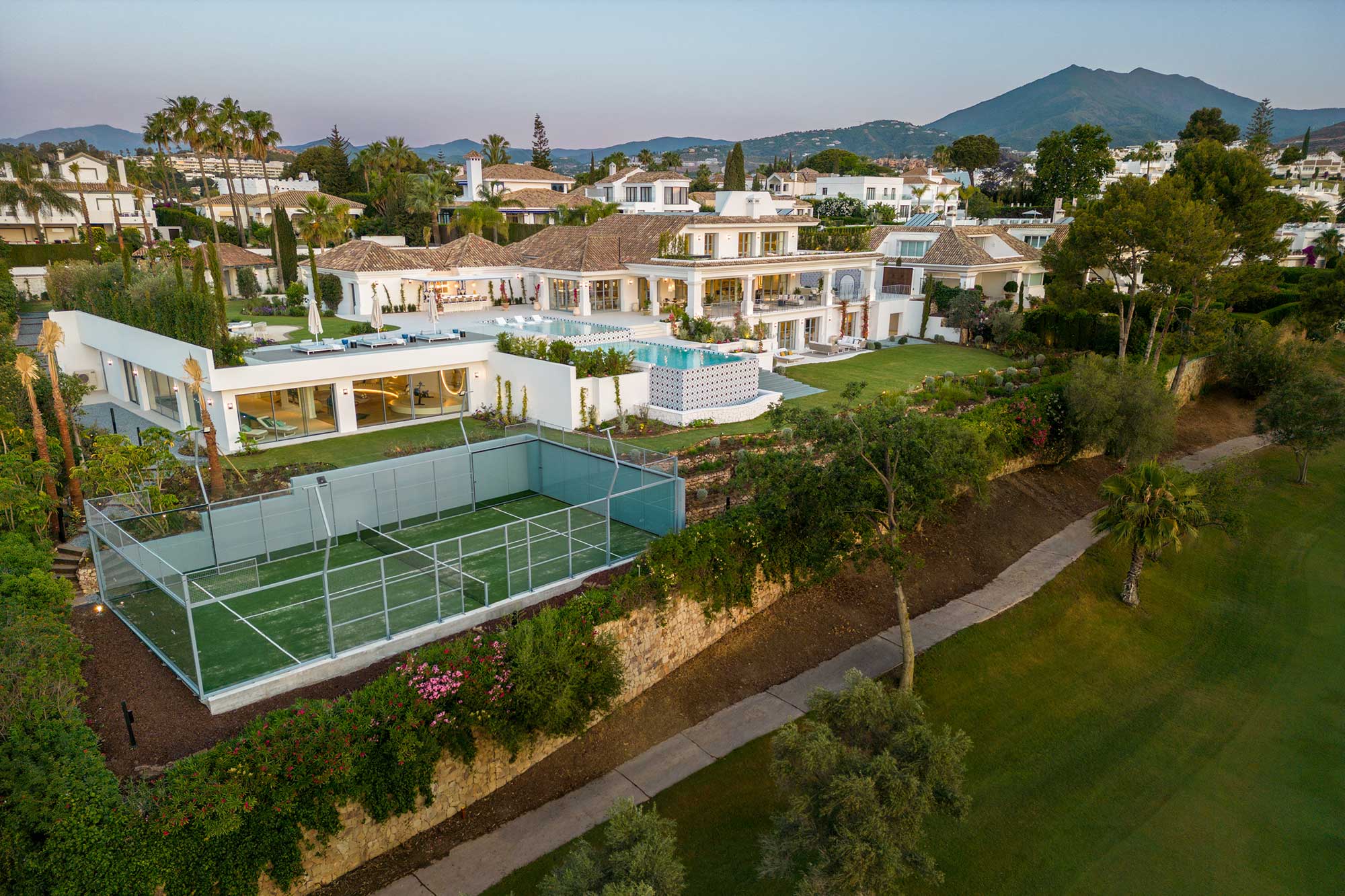 De eigen padelbaan met de villa en het zwembad op de achtergrond
